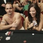 a man and a woman sitting topless on a poker table